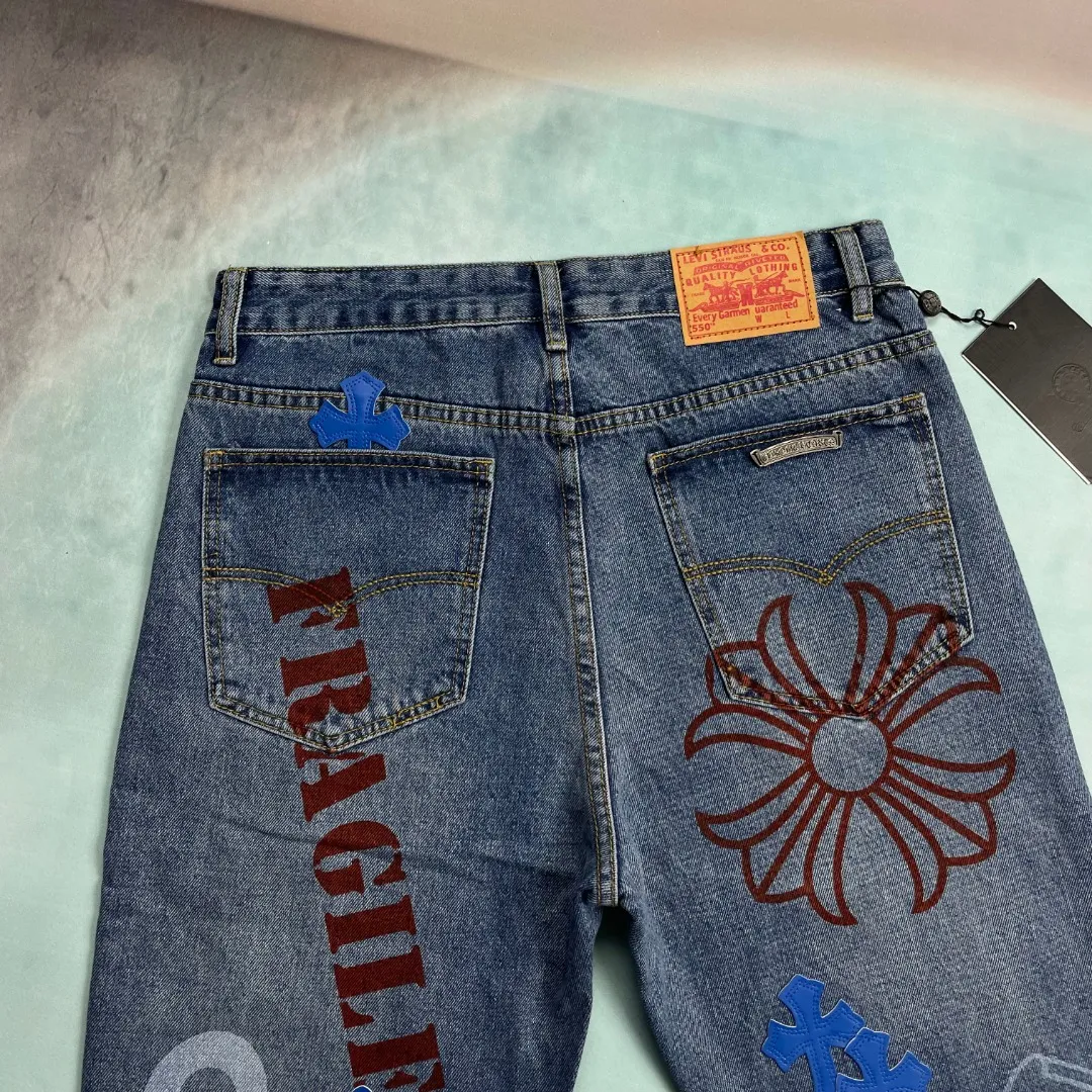 🅿️280 🔘Style No.-KL135 🔘Cro Heart𝐂𝐡𝐫𝐨𝐦𝐞 𝐇𝐞𝐚𝐫𝐭 Sanskrit limited edition graffiti printed cross patch leather jeans* These pants are unique in the selection of fabrics, using thick beaded canvas, which is inherently tough and textured. Subsequently, it undergoes heavy washing. This complex process is like casting magic on the fabric. After being put on the body, it not only feels softer to the touch, but also presents a richer and unique texture. The texture soars straight up, and you can feel its extraordinary quality every time you touch it. At the same time, the washed beaded canvas has excellent breathability. No matter when you wear it, you will never feel hot and stuffy, and you will always stay dry and comfortable. In terms of pattern design, the pants use three-dimensional cutting technology. This is not an ordinary cutting method, but an all-round and precise cutting based on the shape changes of the human body in various postures. As a result, the trousers are exceptionally tall and straight, and can perfectly fit the leg lines. Whether standing upright or walking freely, they can show a neat and cool posture, greatly modify the leg shape, and highlight the elegance of the wearer. The details highlight the high quality and unique charm of these pants. The hardware is customized from ZP. Its quality is extraordinary, its glossiness and durability are far superior to ordinary hardware. Every buckle is smooth and smooth, and it will not fade or wear out after long-term use. The customized small leather label is uniquely designed. It is a small piece of leather label, but it incorporates the designer's ingenuity. The patterns and textures on it are exquisite and delicate, highlighting the high-end tone of the brand. The workmanship of the trousers is exquisite, and every line is neatly and carefully arranged. Whether it is the trousers seam, splicing, or pocket edges, they are all handled extremely well. From the overall design to the details, they adhere to the concept of simplicity and elegance, showing the beauty of the details vividly.  Size: S M L XL (28.30.32.34) Color: Blue
